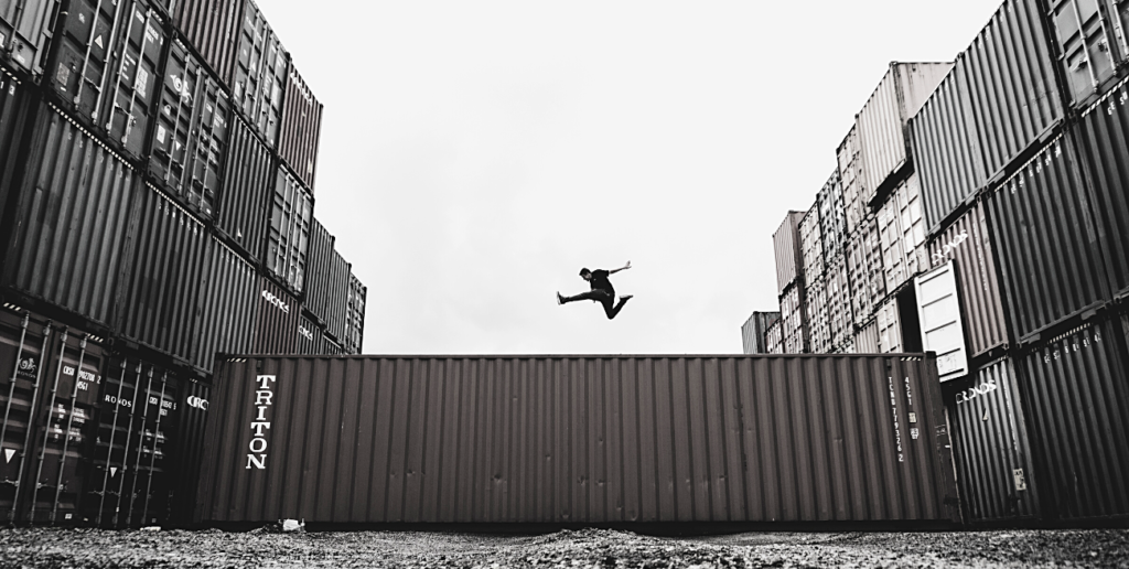 persona saltando sobre containers
